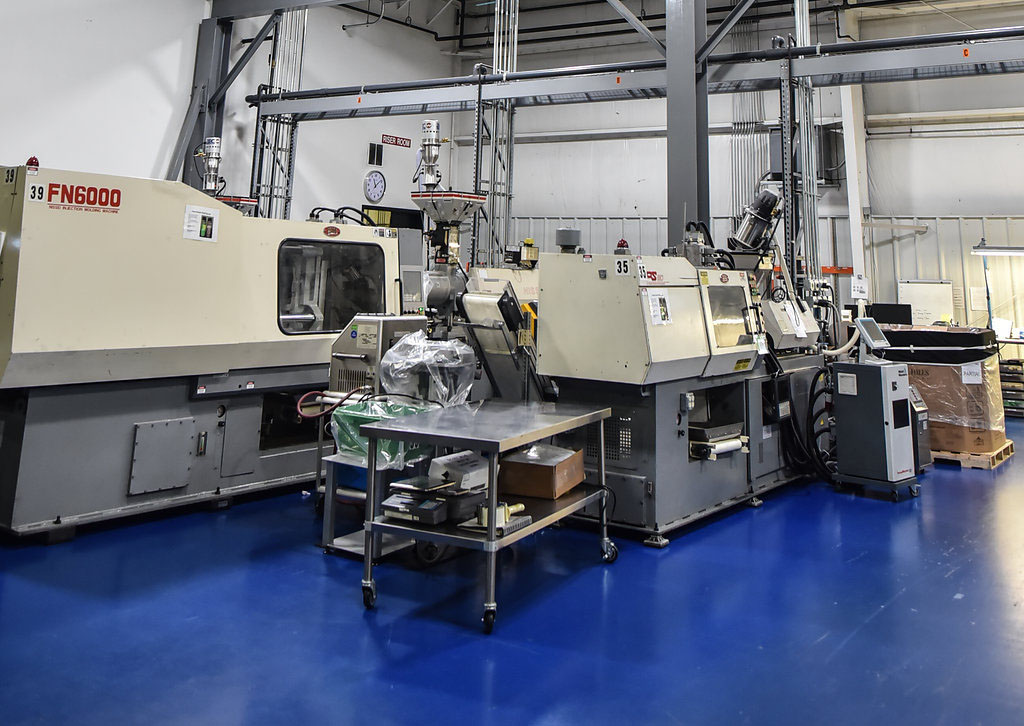 wide view of factory floor with injection machine and crane above